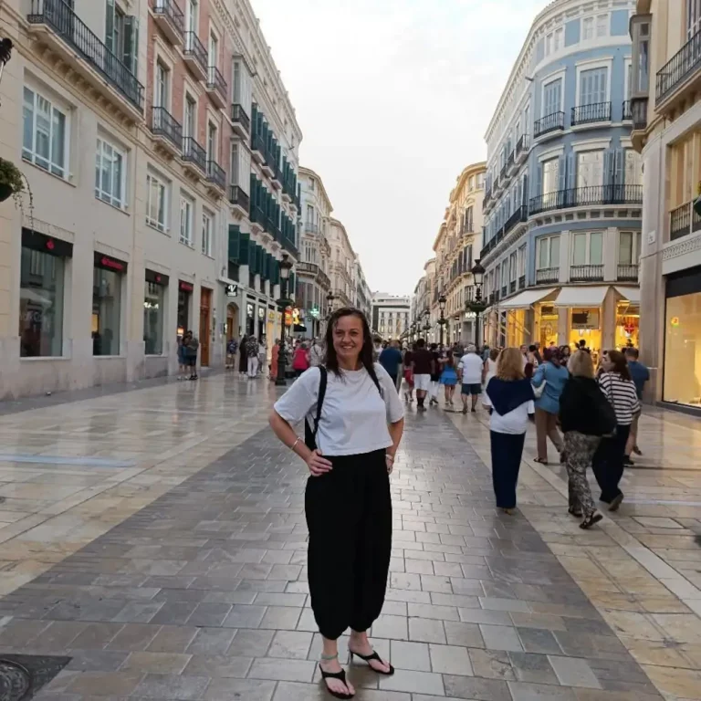 Emma Fairhurst, owner of TrewCut hairdressers, standing in historic European shopping street during holiday